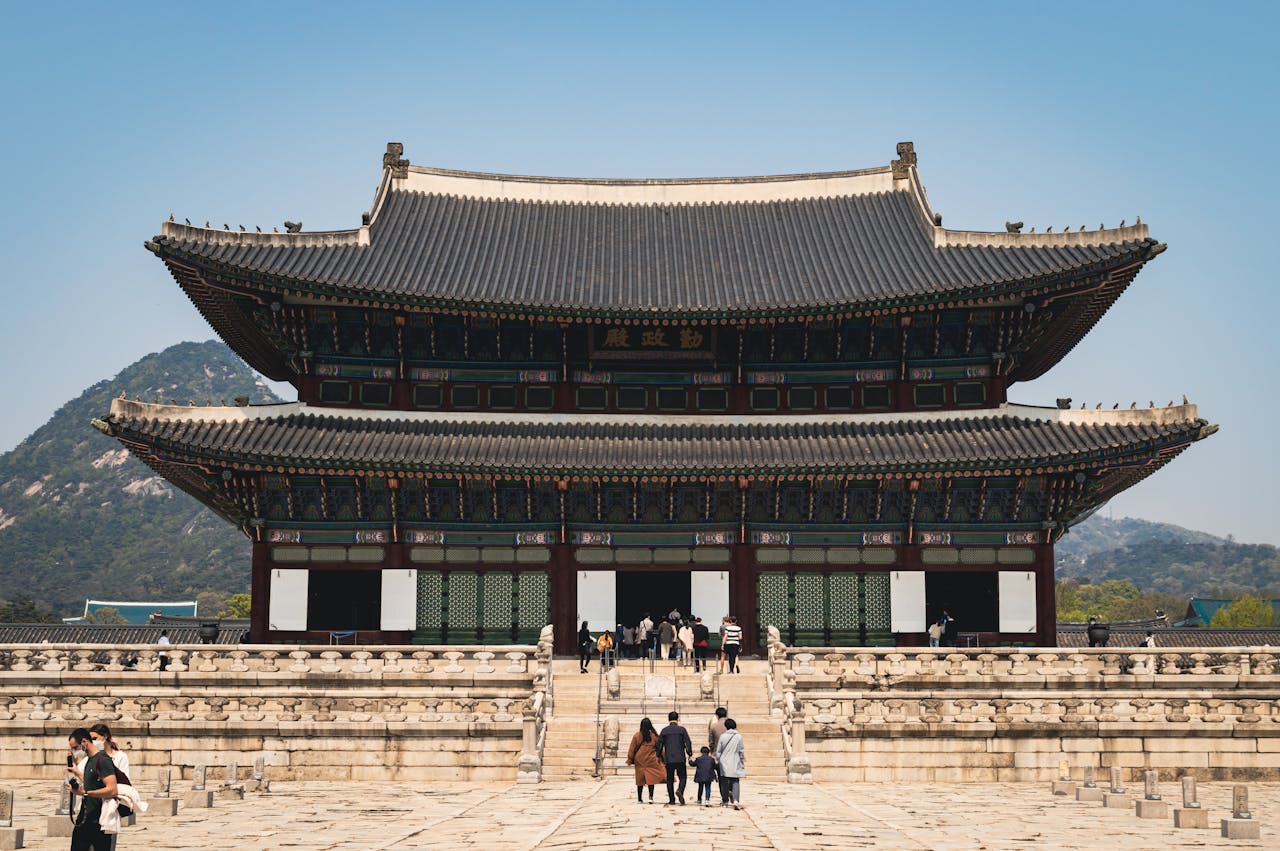 Tourists at the grand entrance of Gyeongbokgung Palace in Seoul, South Korea, capturing its historical architecture.