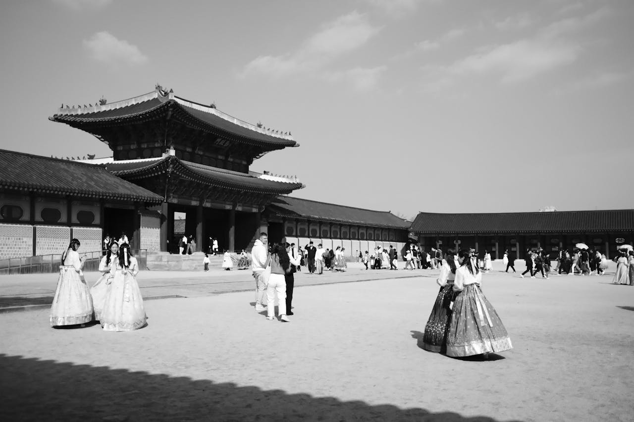 People in traditional clothing near a historic temple in Seoul showcasing Korean culture and architecture.