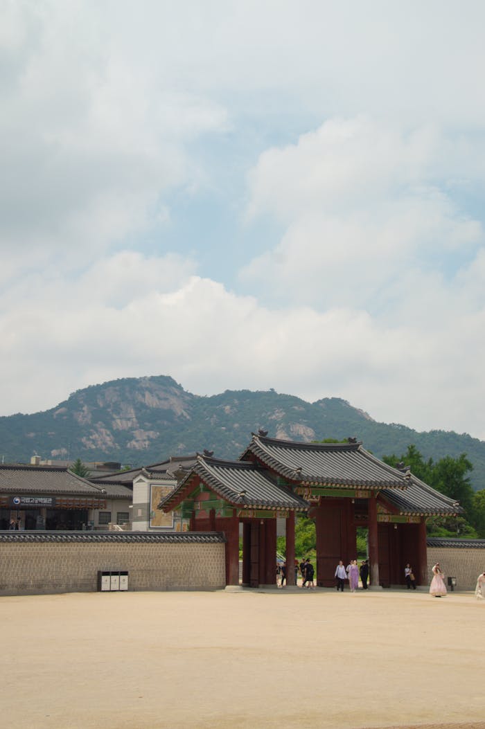 Traditional gate at Gyeongbokgung Palace with mountain backdrop in Seoul, South Korea.